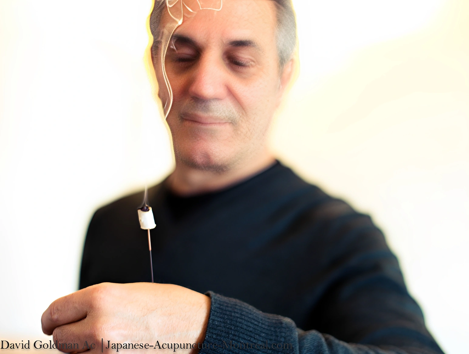 Man holding a burning incense stick